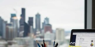 A chaotic desk with an SEO mug and a sticky note.